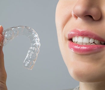 Woman holding clear aligners