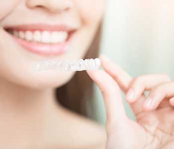 Woman putting in clear aligners