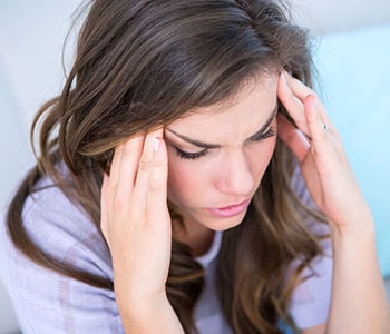 Woman holding her head in pain