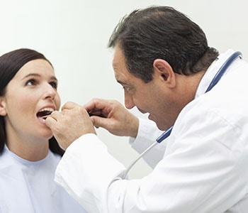 Male dentist examining a female patient