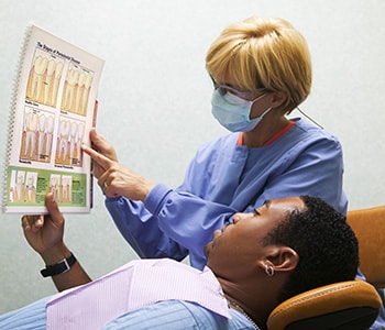 Female dentist showing something to a male patient