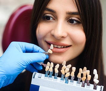 Female patient looking at different shades of restorations