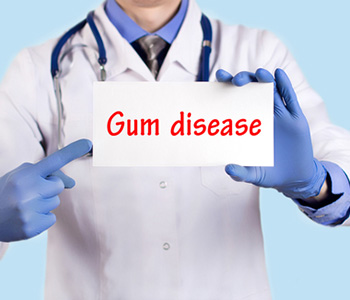 Dentist holding up a sign that says gum disease