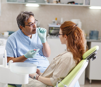 Male dentist talking to female patient