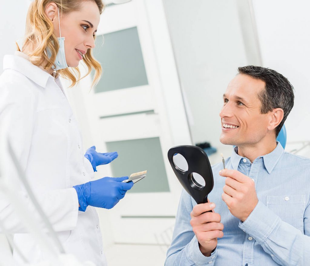 Male patient talking to female hygienist