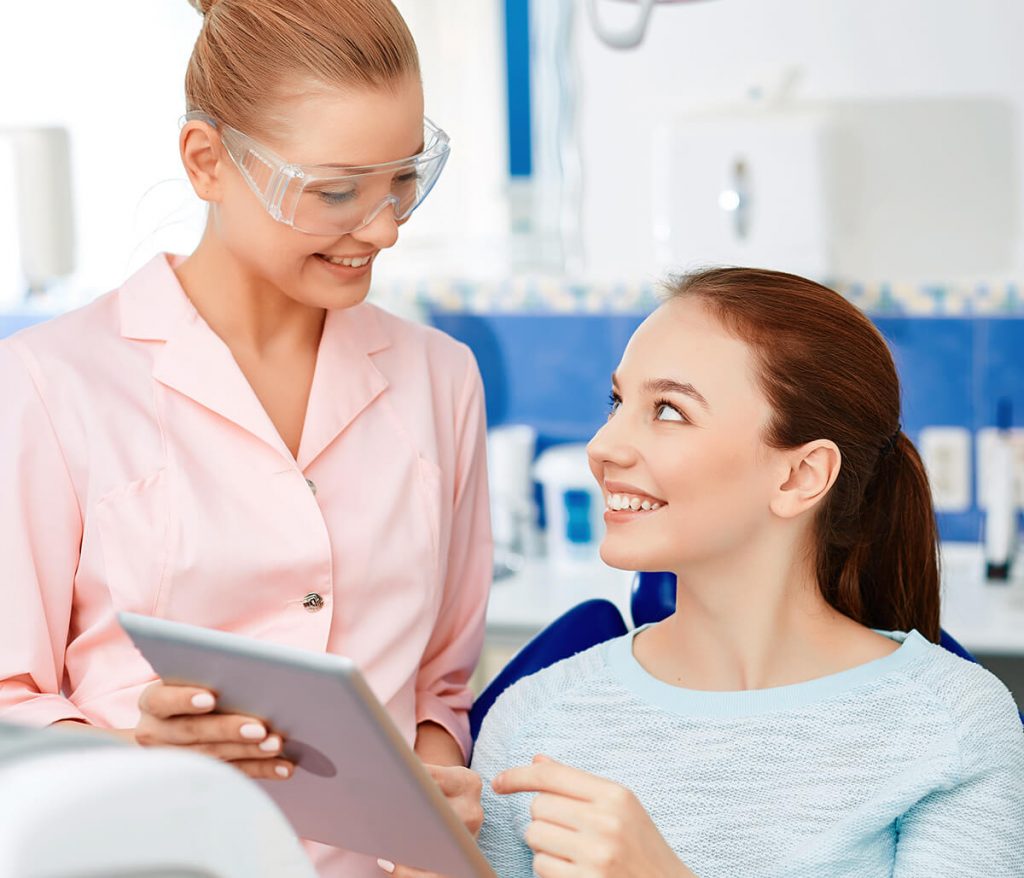 Young female patient talking to female hygienist