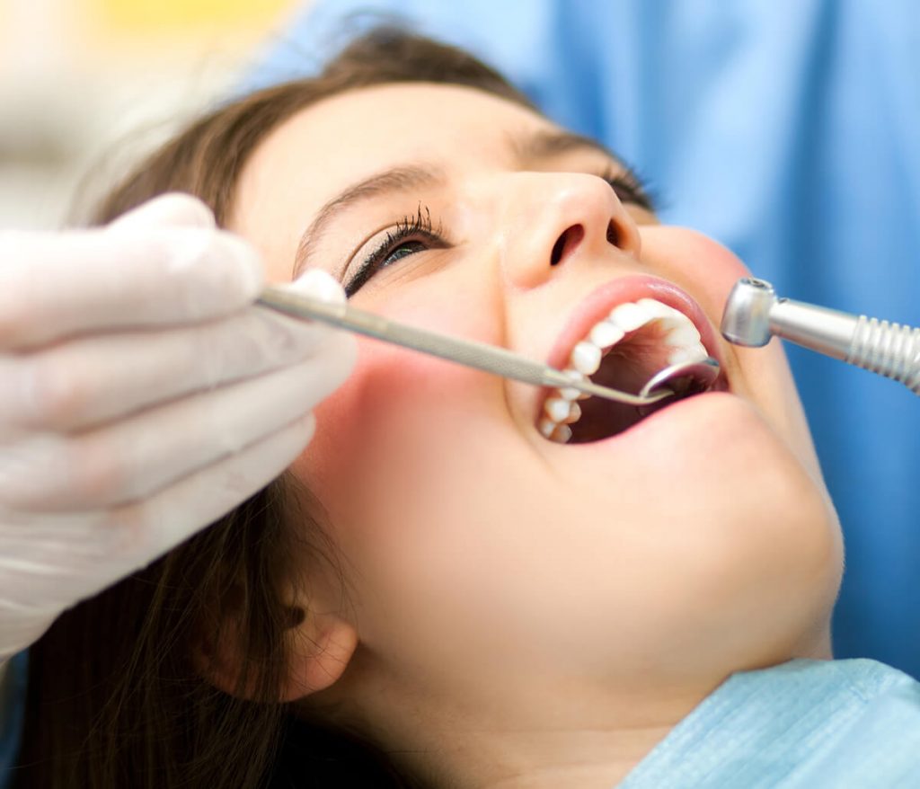 Young woman getting her teeth whitened