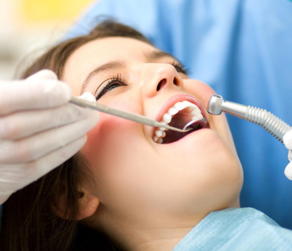 Young woman getting her teeth whitened