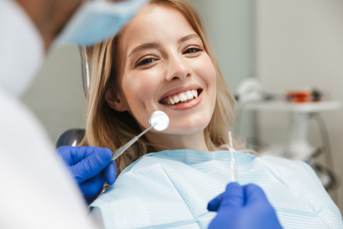 satisfied young woman sitting in dental chair