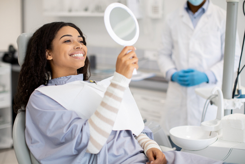 woman smiling in hand mirror